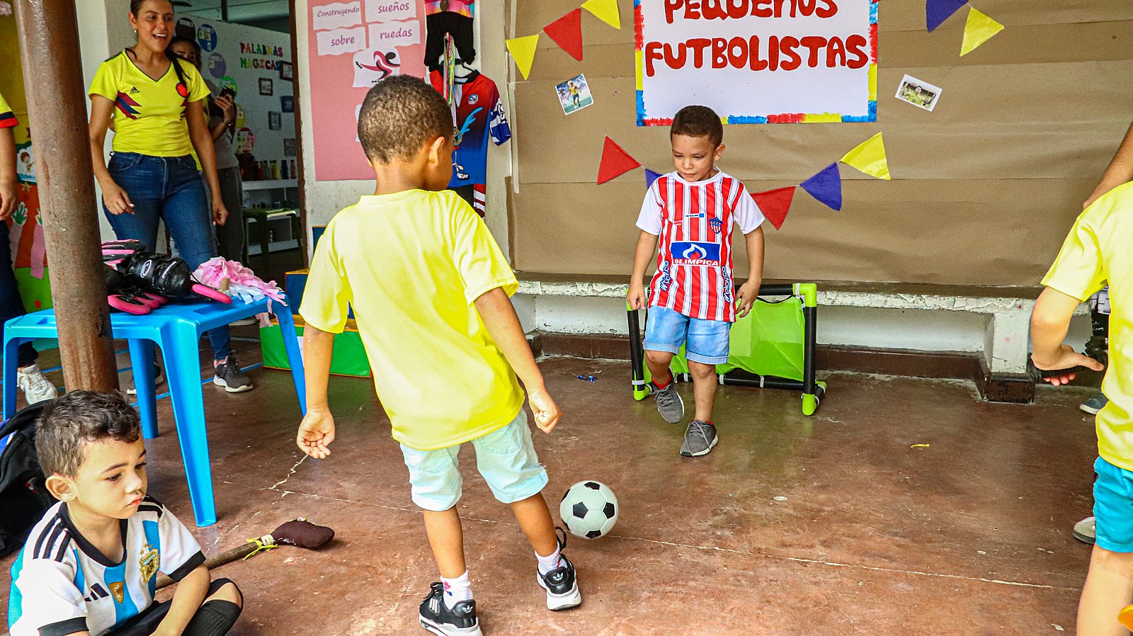 Niño pateando un balón hacia la portería en una actividad de fútbol