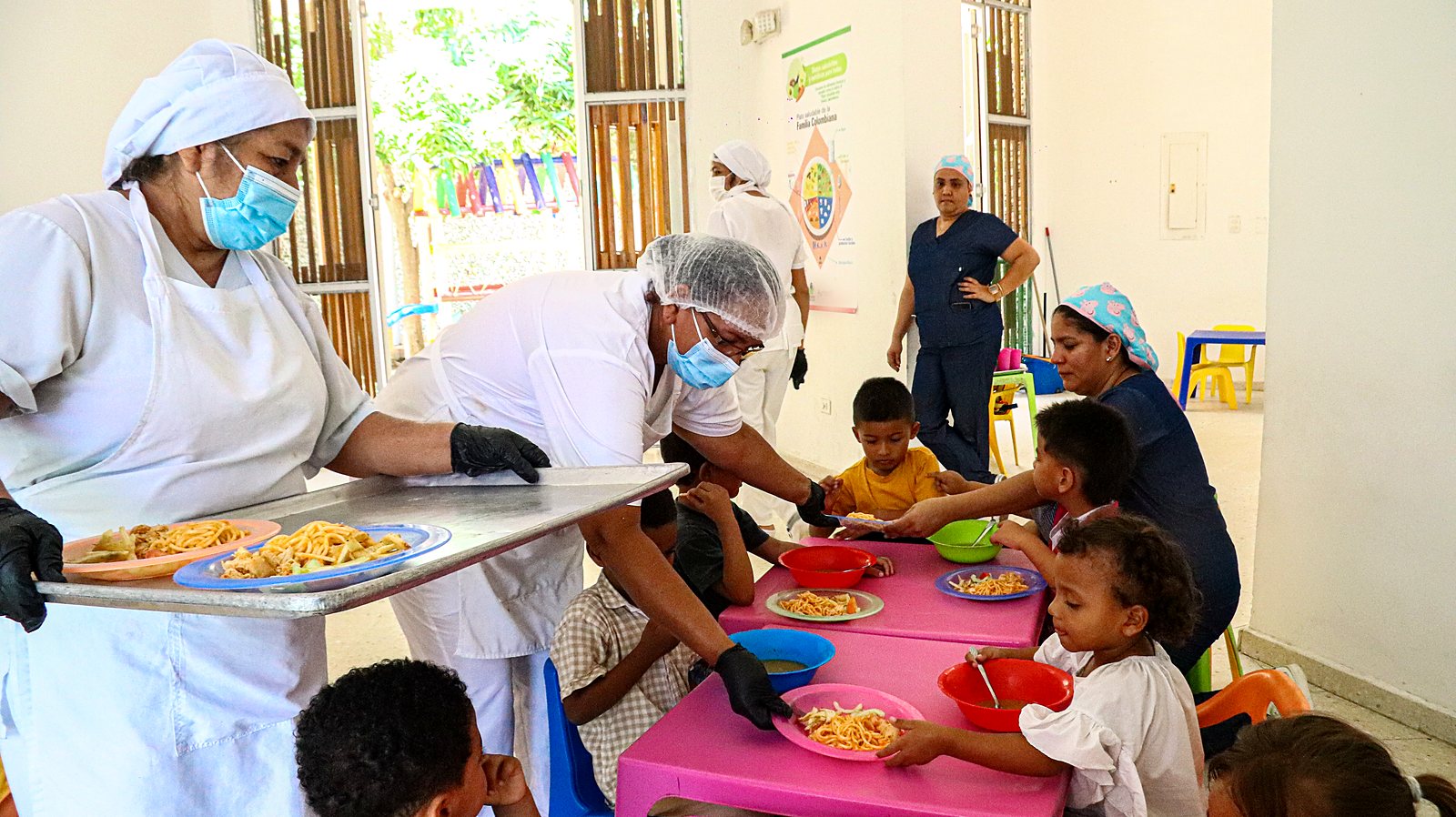 Manipuladoras de alimentos sirviendo el almuerzo a los niños